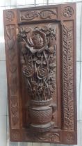 Ornately carved oak panel with relief decoration of a basket of roses with thistles, the borders