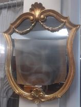 Modern gilt framed shield shaped mirror with shell pediment, swags and scrolls. 61x48cm approx. (B.