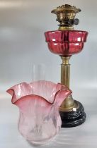 Early 20th Century double oil burner lamp, having cranberry etched glass foliate shade above a