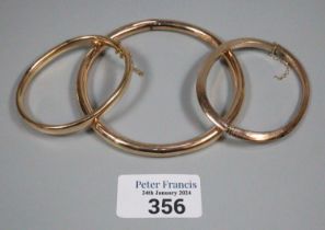 Two 9ct gold bangles. 23.5g approx., together with another yellow metal bangle. 10.5g approx. (3) (