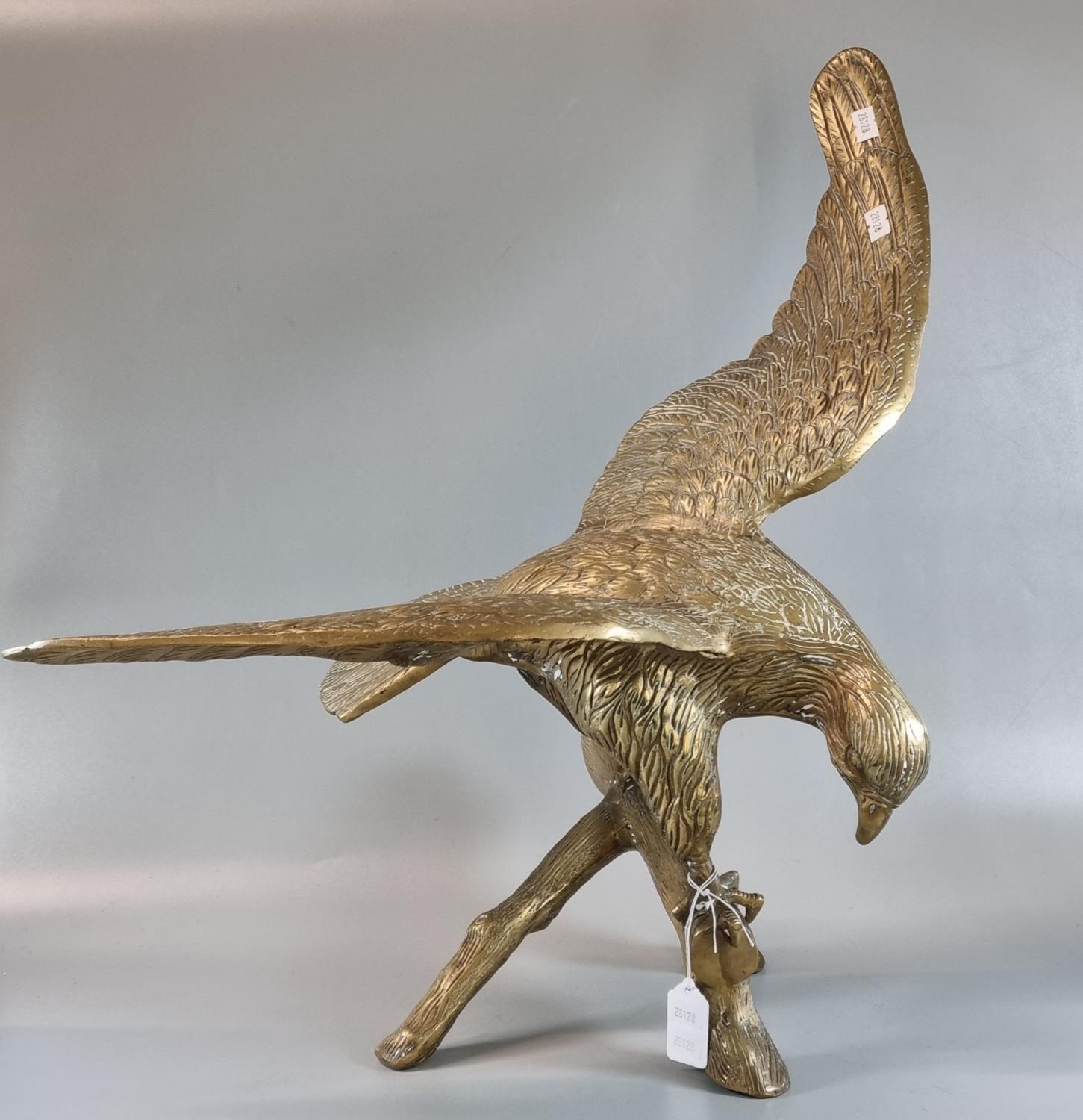 Brass sculpture of an eagle with outstretched wings, alighting on a branch. 55cm wide approx. (B.