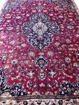 Rich red ground Persian Mashad carpet with traditional floral medallion designs. 305x223cm