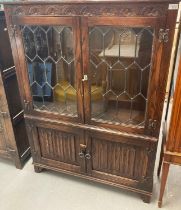 Two items of 17th century style reproduction oak furniture to include: lead glazed low bookcase with