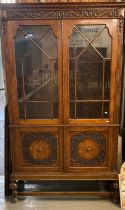 Good quality early 20th century oak glazed bookcase with moulded panel doors below on cup and