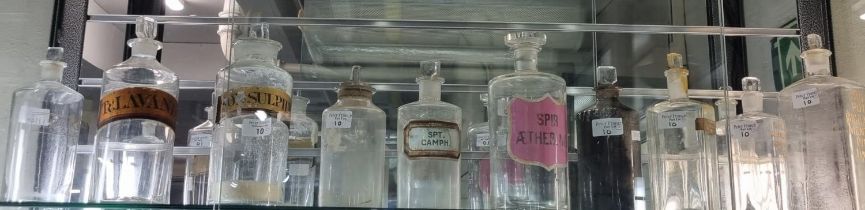 Collection of 19th century apothecary jars and stoppers, mainly clear glass with labels to