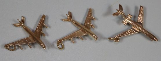 Three 9ct gold charms in the form of aeroplanes marked 'Bermuda New York'. 6.3g approx. (B.P.