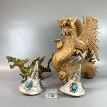 Carved wooden sculpture of a dragon, together with a brass dragon and a pair of Tibetan conch shells