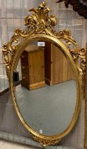 Modern gilt framed bevelled mirror decorated with pierced flowers and foliage. 84cm high approx. (