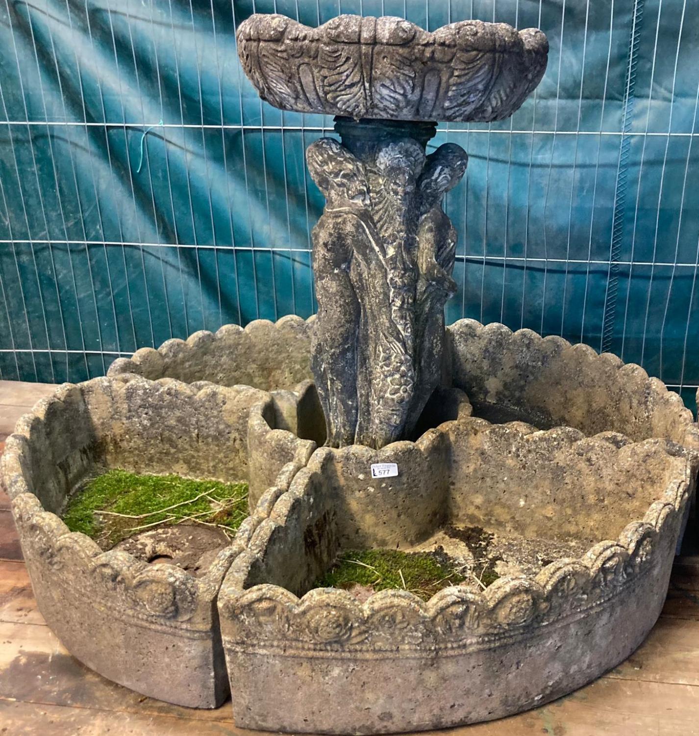 Reconstituted stone garden bird bath with figural pedestal and segmented planters around the base.