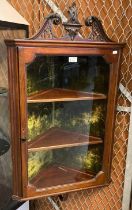 Edwardian mahogany single door hanging corner cabinet, the broken swan neck above three fitted