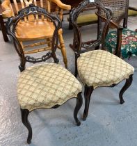 Pair of Victorian carved walnut dining chairs with stuff-over serpentine seats and cabriole legs. (