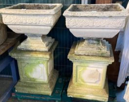 Pair of square shaped reconstituted stone garden urns on panelled pedestal bases. 92cm high