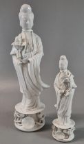 Two Chines porcelain Blanc de Chine figures of Guanyin The Goddess of Mercy, both standing on