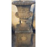 Reconstituted stone mask mounted Campana shaped garden urn on square shaped pedestal base.(B.P.