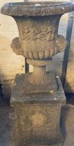 Reconstituted stone mask mounted Campana shaped garden urn on square shaped pedestal base.(B.P.