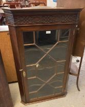 19th century mahogany hanging corner cabinet, the dental and fretwork cornice above an astragal