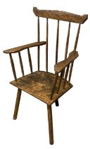 Primitive elm and ash stick backed chair with shaped arms and solid seat on three turned legs. (B.P.