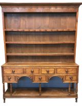 Early 19th century Welsh oak pot board dresser having three shelf boarded rack back with moulded