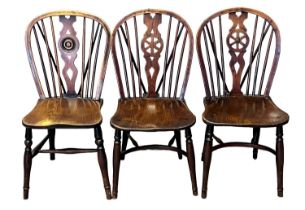 A Harlequin group of three 19th Century wheel backed elm and yew and ash single chairs with