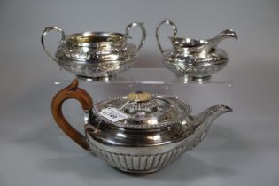 Early 19th century silver baluster shaped teapot with turned wooden handle, engraved armorial and