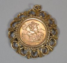 George V gold full sovereign inset in ornate 9ct gold pendant mount, the sovereign dated 1932. 13g