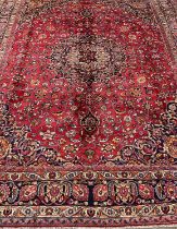 Large red ground Persian Mashad carpet, overall on a red ground with floral and foliate designs,