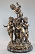 A bronze figure group of dancing cherubs around a central figure on naturalistic circular base and