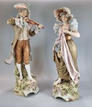 Pair of Royal Dux figures, of a musician playing his violin and a maiden in floral shawl and bonnet.