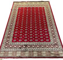 Red ground full pile Kashmir carpet with all over traditional Bokhara designs. 300 x 200cm