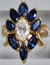 18ct gold oval cut diamond and eight stone tanzanite flowerhead ring. 5.2g approx. Ring size K. (B.