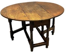 18th Century oval oak gate legged table having two drop flaps, single end drawer and a gun barrel