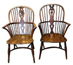 A similar group of four 19th Century elm and yew Windsor wheel and splat backed elbow chairs, all