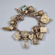 9ct rose gold curb link charm bracelet with various charms including; football, bottle, heart shaped