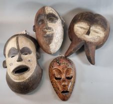 Collection of four unusual African Tribal masks with stylised features, the largest 34cm high