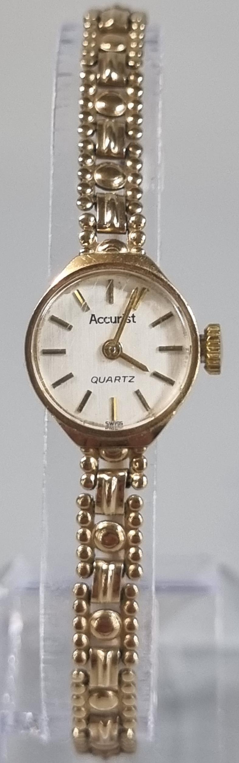 Accurist 9ct gold small head ladies wristwatch with satin face having baton numerals on a 9ct gold