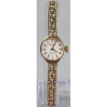 Accurist 9ct gold small head ladies wristwatch with satin face having baton numerals on a 9ct gold