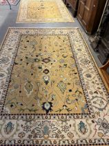 Two similar peach and ivory ground tradition wool area rugs, both decorated with flowers and foliage