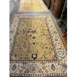 Two similar peach and ivory ground tradition wool area rugs, both decorated with flowers and foliage