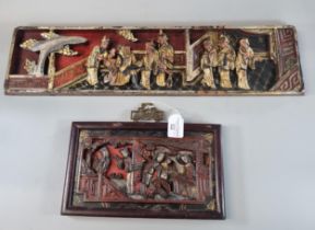 Two Chinese carved wooden polychrome panels depicting figures in an interior, the largest 55cm