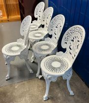 A Set of five cast metal white painted garden chairs with arched scrolled backs and circular pierced