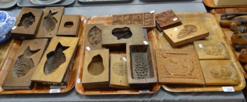 Three trays of carved wooden items; butter and other moulds to include: fish, fan, chrysanthemum,