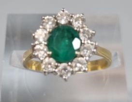 18ct gold flower head ring with ten diamonds and central emerald stone. 3.2g approx. Size J. (B.P.