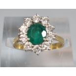 18ct gold flower head ring with ten diamonds and central emerald stone. 3.2g approx. Size J. (B.P.