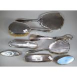 Collection of silver topped ladies vanity items to include: brushes, hand mirror, beaten design