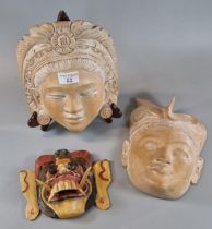 Two similar Balinese carved hardwood maskheads of a young man and lady in headdress and earrings