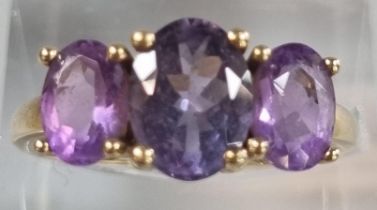 9ct gold and purple three stone dress ring. 2.7g approx. Size P. (B.P. 21% + VAT)