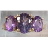 9ct gold and purple three stone dress ring. 2.7g approx. Size P. (B.P. 21% + VAT)