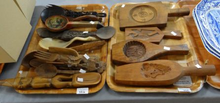 Two trays of carved wooden items to include: oriental design butter pats, scoops and cutlery,