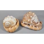 Two similar cameo conch shells ornately carved with a maiden and mythical dolphins and George