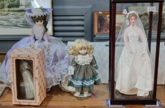 Collection of Franklin Heirloom porcelain dolls, three in perspex and wooden cases together some